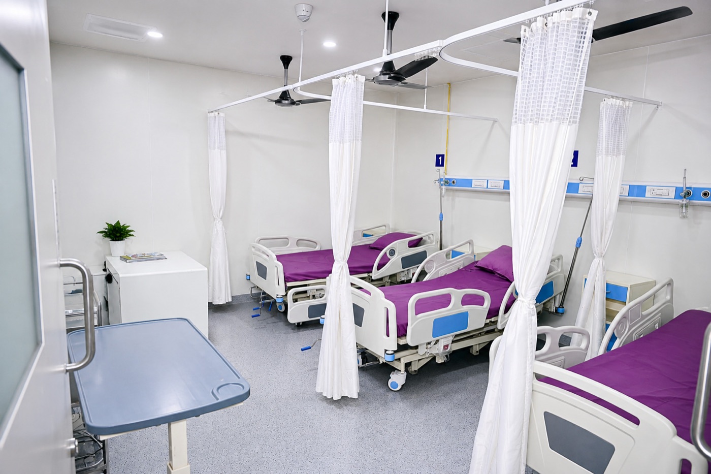 Post-operative recovery ward with curtained beds at Sharada Hospital